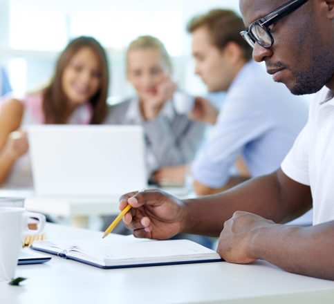 Plans Concentrated young man in the foreground planning his workday